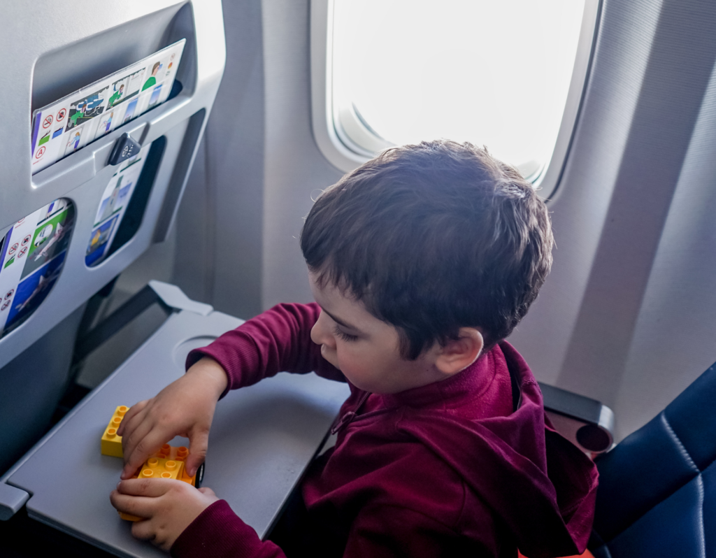 boy playing with toys on airplane tray table