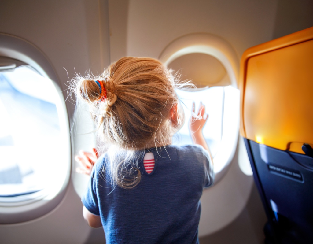 little girl looking out of airplane window