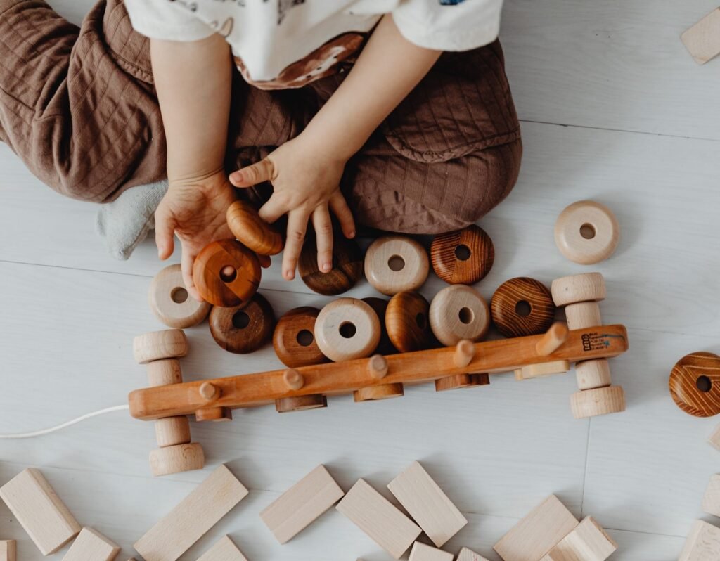 boy playing with wooden toys in a clean environment with white floor