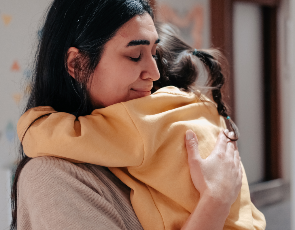 mom comforting toddler after tantrum with a loving hug