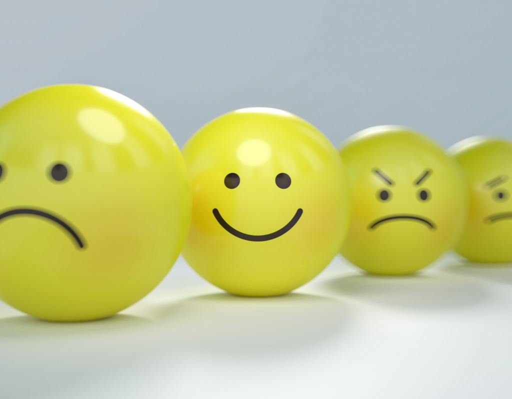 circlular yellow balls with faces on them displaying a range of emotions from sad, happy to mad and concerned 