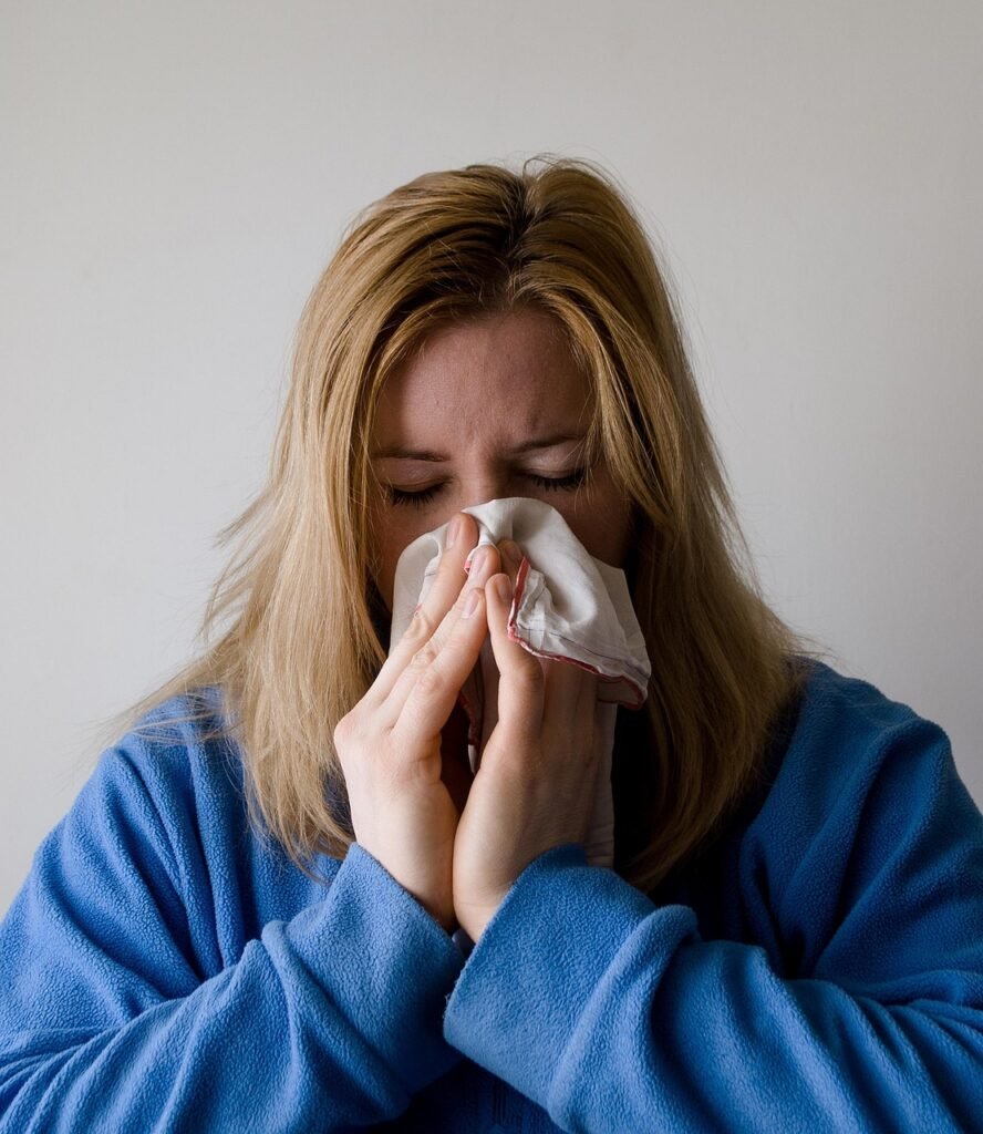 woman with tissue covering her nose- representing chronic illness