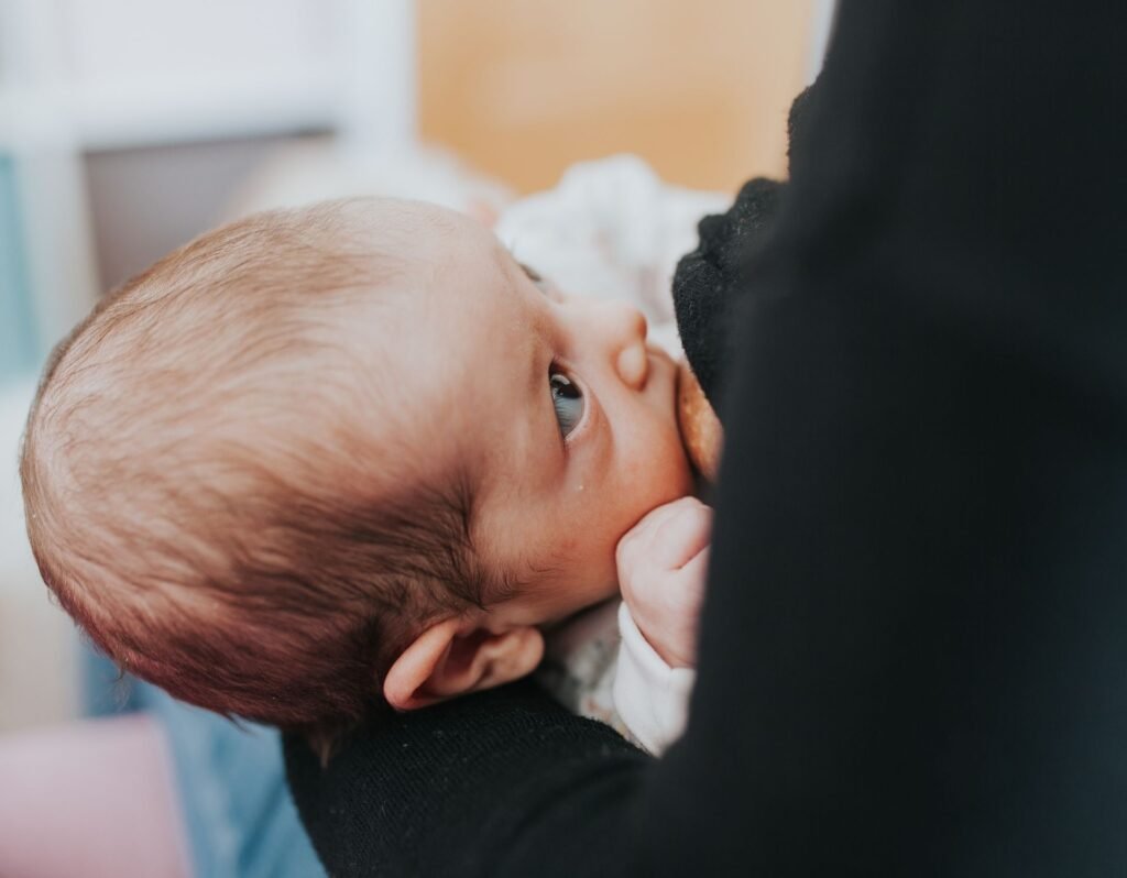 baby breastfeeding looking up at mom