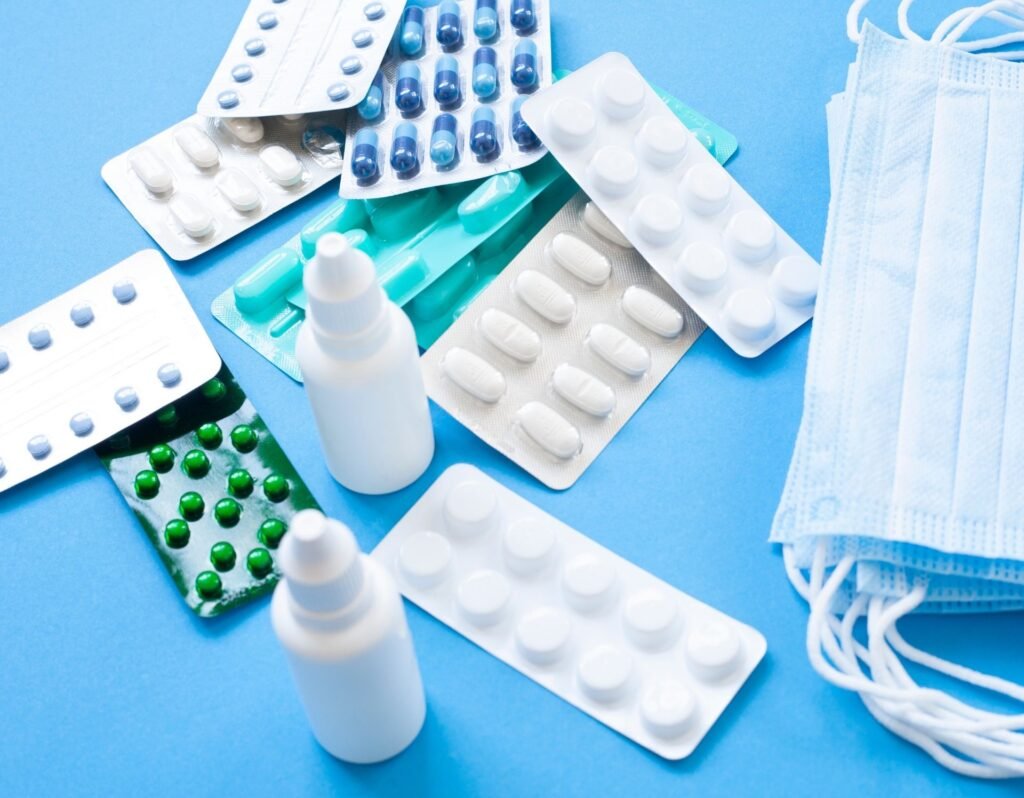 medicine, masks, pills, bottles of medication, blue background first aid sick preparedness kit