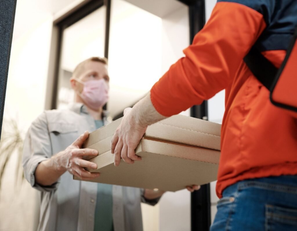 pizza delivery with sick man receiving pizza wearing a mask