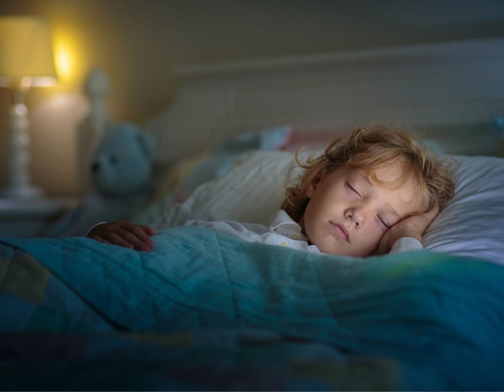 child sleeping in bed with dark room and lamp turned on on their side table- why toddlers cry when they wake up