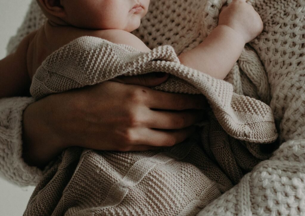mom holding baby wrapped in blanket